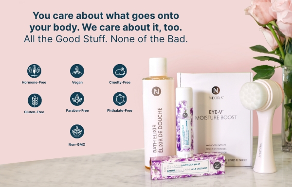 Neora’s Make Her Mother’s Day Bundle which includes: Zen + Calm Lavender Balm, Bath Elixir, Eye-V Moisture Boost Hydrogel Patches and a FREE dual-sided Facial Scrubber sitting on a counter next to flowers. 